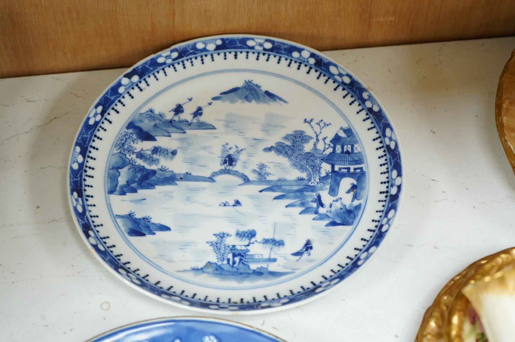 A 19th century Chinese blue landscape plate another smaller, prunus plate, another with restored rim, largest 22.5cm diameter.
